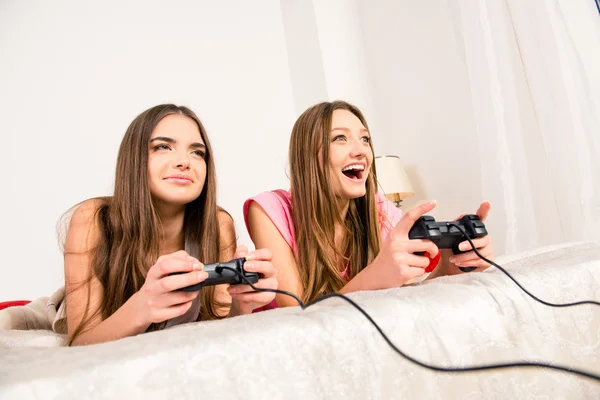 Gelukkig vreugdevolle vriendinnen spelen van videospellen met joysticks op t — Stockfoto