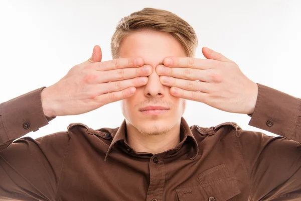 Feche a foto do jovem homem bonito fechando os olhos com as mãos — Fotografia de Stock