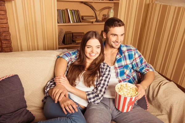 Paar genieten van lettend op een film thuis met popcorn — Stockfoto