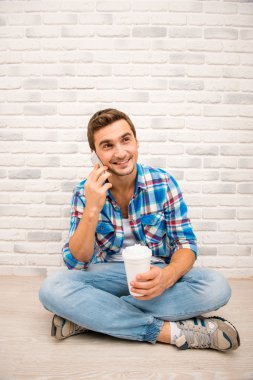 Young smiling man ralking by mobile phone clipart