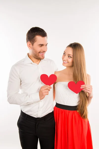 Весела пара закоханих тримає два червоних паперових серця — стокове фото