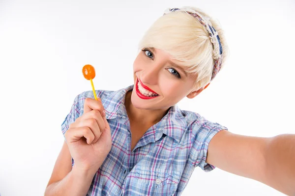 Cheerful girl licking lollipop and making selfie photo — Stock Photo, Image