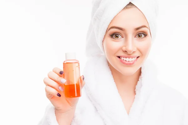 Menina bonita com toalha na cabeça segurando shampoo — Fotografia de Stock