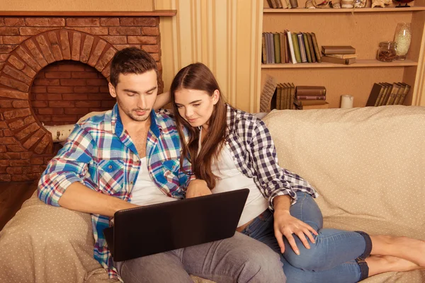 Beautiful couple in love  sitting on the sofa with laptop — Stock Photo, Image