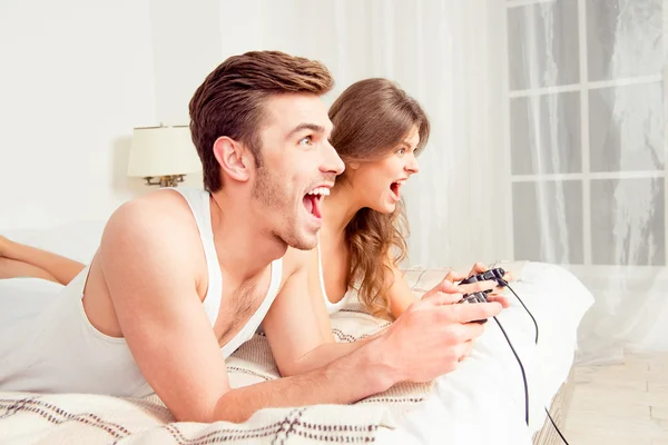 Vrolijke paar verliefd spelen van videogames in slaapkamer — Stockfoto