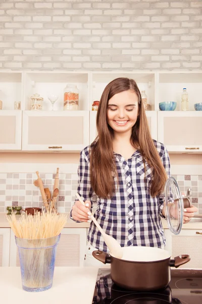 Gelukkig jonge vrouw kokend spaghetti in de keuken — Stockfoto