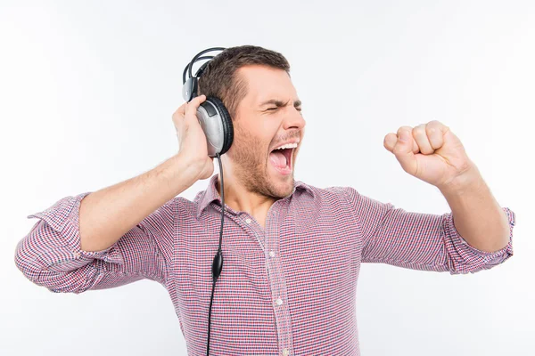 Molinillo hombre con auriculares cantando en la mano como en el micrófono — Foto de Stock