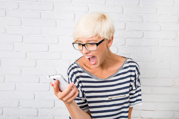Blonde girl shouts in anger to her phone — Stock Photo, Image