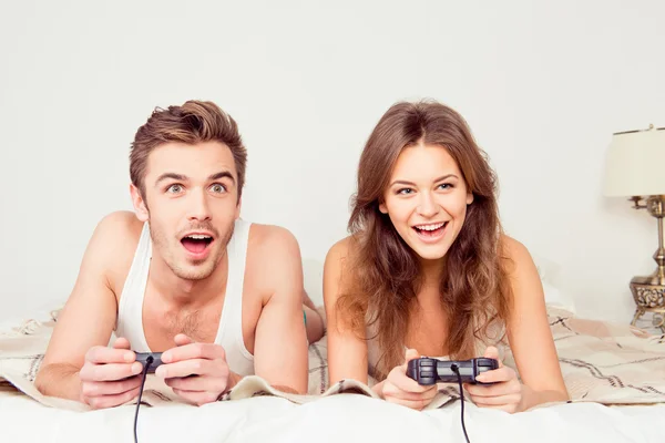 Couple joyeux en amour jouer à des jeux vidéo avec des joysticks sur le th Photo De Stock