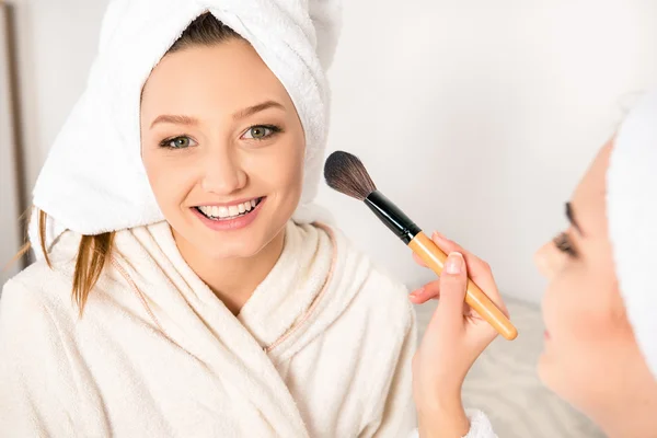 Flotte unge kvinder gør makeup med håndklæder på deres hoveder - Stock-foto