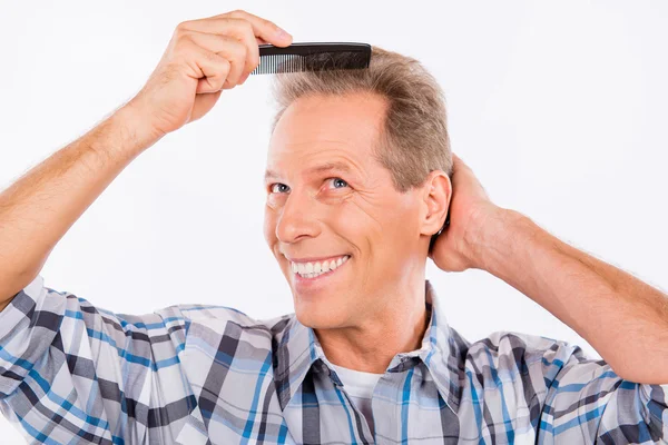 Handsome happy aged man combing his hair — Stock Photo, Image