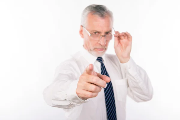 Velho empresário segurando seus óculos e apontando para a câmera — Fotografia de Stock