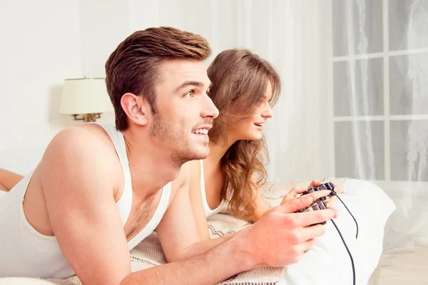 Paar verliefd spelen van videogames in slaapkamer, zijkant weergave — Stockfoto