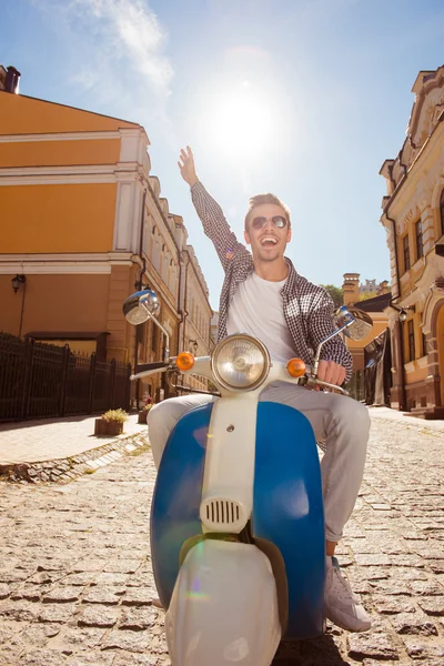 Bonito homem feliz montando uma moto pegando mão — Fotografia de Stock