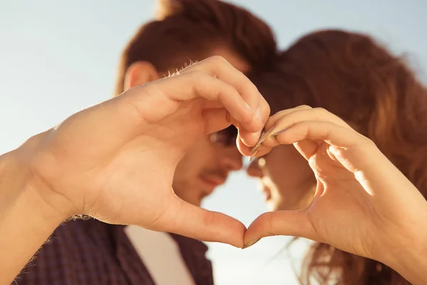 Suave casal doce no amor gesticulando um coração com os dedos — Fotografia de Stock