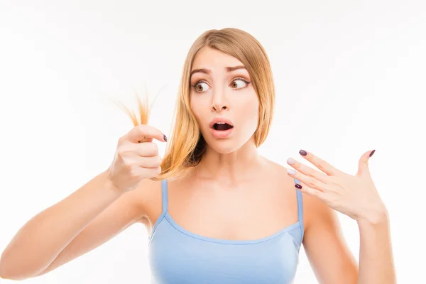 Young shocked woman looking at damaged split ends — Stock Photo, Image