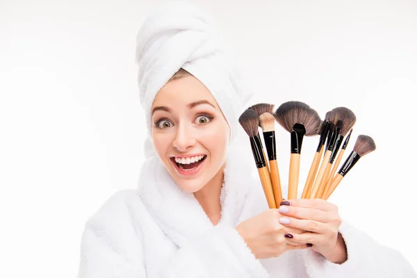 Niza joven mujer sosteniendo cepillos de maquillaje con toalla en la cabeza — Foto de Stock