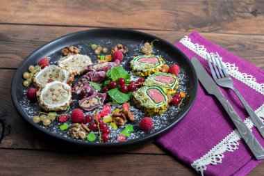 Siyah tabakta meyve ve böğürtlenli Gürcü tatlıları