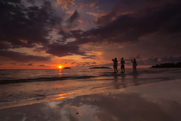 İnsanlar bir plaj gün batımı görünümü o tadını çıkarın.