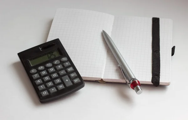 Concepto de negocio con calculadora, cuaderno y pluma — Foto de Stock