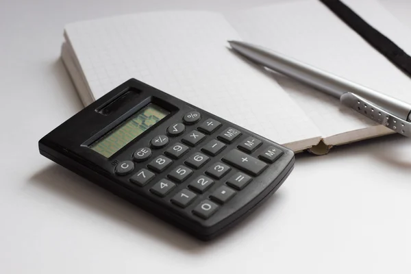 Concepto de negocio con calculadora, cuaderno y pluma — Foto de Stock