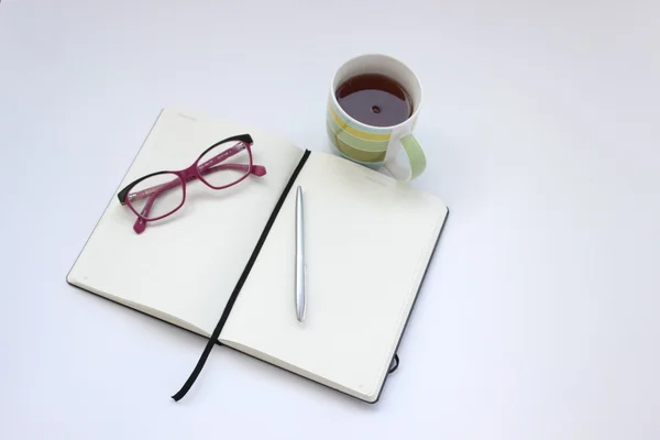 Cuaderno abierto en blanco con taza de té y pluma — Foto de Stock