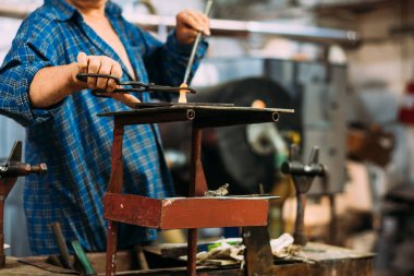 Sanatçı cam heykelcikler yapar.