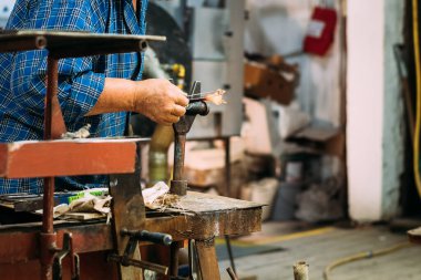 Sanatçı cam heykelcikler yapar.