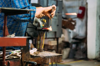 Sanatçı cam heykelcikler yapar.