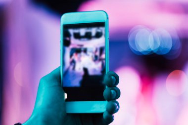 Kulüpteki bir partide telefonunla fotoğraf çekiyorsun.