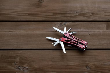 Çoklu işlevsel cep çakısı bir keseyi ahşap bir masaya yerleştirilir.