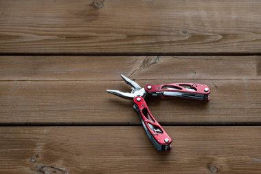 Çoklu işlevsel cep çakısı bir keseyi ahşap bir masaya yerleştirilir.