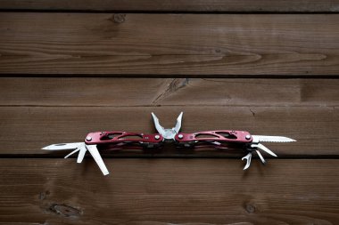 Çoklu işlevsel cep çakısı bir keseyi ahşap bir masaya yerleştirilir.