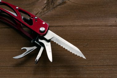 Çoklu işlevsel cep çakısı bir keseyi ahşap bir masaya yerleştirilir.