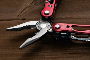 Çoklu işlevsel cep çakısı bir keseyi ahşap bir masaya yerleştirilir.