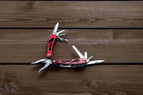 Çoklu işlevsel cep çakısı bir keseyi ahşap bir masaya yerleştirilir.