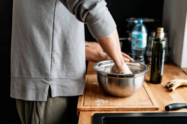 Adam pizza hamuru yapıyor.