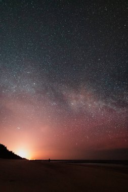 Gece gökyüzü deniz kenarında Samanyolu görünür