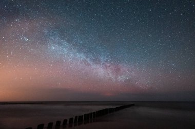 Gece gökyüzü deniz kenarında Samanyolu görünür