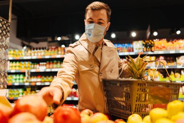 Karantina sırasında süpermarkette maske takan bir adam.