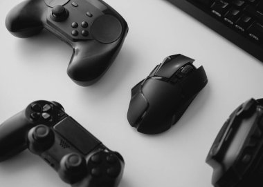 Oyun teçhizatı, fare, klavye, joystick, beyaz masa arka planında kulaklık içeren oyun alanı kavramı.