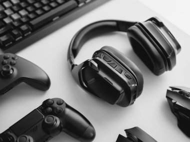 Oyun teçhizatı, fare, klavye, joystick, beyaz masa arka planında kulaklık içeren oyun alanı kavramı.