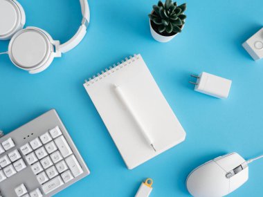 Not defteri, plastik fabrikası, akıllı telefonu ve klavyesi olan ofis masasının üst görünümü mavi masa arkaplanı, grafik tasarımcısı, yaratıcı tasarımcı konsepti.