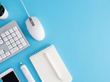 Not defteri, plastik fabrikası, akıllı telefonu ve klavyesi olan ofis masasının üst görünümü mavi masa arkaplanı, grafik tasarımcısı, yaratıcı tasarımcı konsepti.