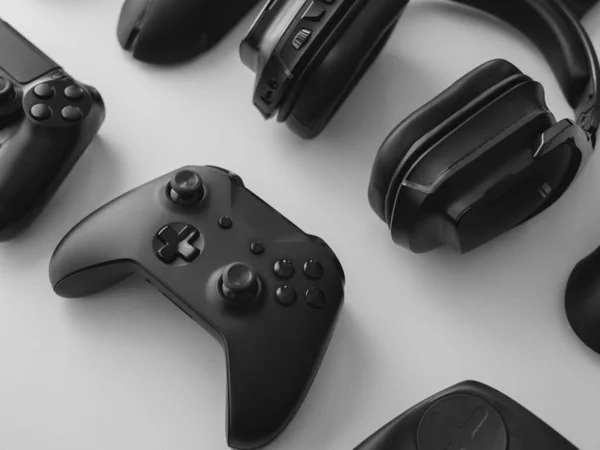 Oyun teçhizatı, fare, klavye, joystick, beyaz masa arka planında kulaklık içeren oyun alanı kavramı.