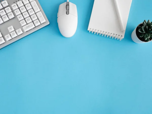 Not defteri, plastik fabrikası, akıllı telefonu ve klavyesi olan ofis masasının üst görünümü mavi masa arkaplanı, grafik tasarımcısı, yaratıcı tasarımcı konsepti.