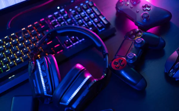 oyun alanı konsepti, üst görünüm oyun teçhizatı, fare, klavye, joystick, rgb renk içeren kulaklık siyah masa arkaplanı.