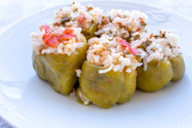 Doldurulmuş biber. Beyaz tabakta doldurulmuş biberlerin yakın plan fotoğrafı. Geleneksel Türk yemekleri. Yiyecek sunumu.