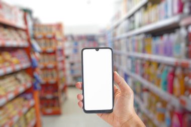 Beyaz ekranlı akıllı telefon, arka planda bulanık süpermarket görüntüsü, online alışveriş konsepti, model resim.