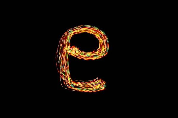 Lower case letter e. Light painting alphabet. Long exposure photography. Drawing letter e with colorful lights on black background.